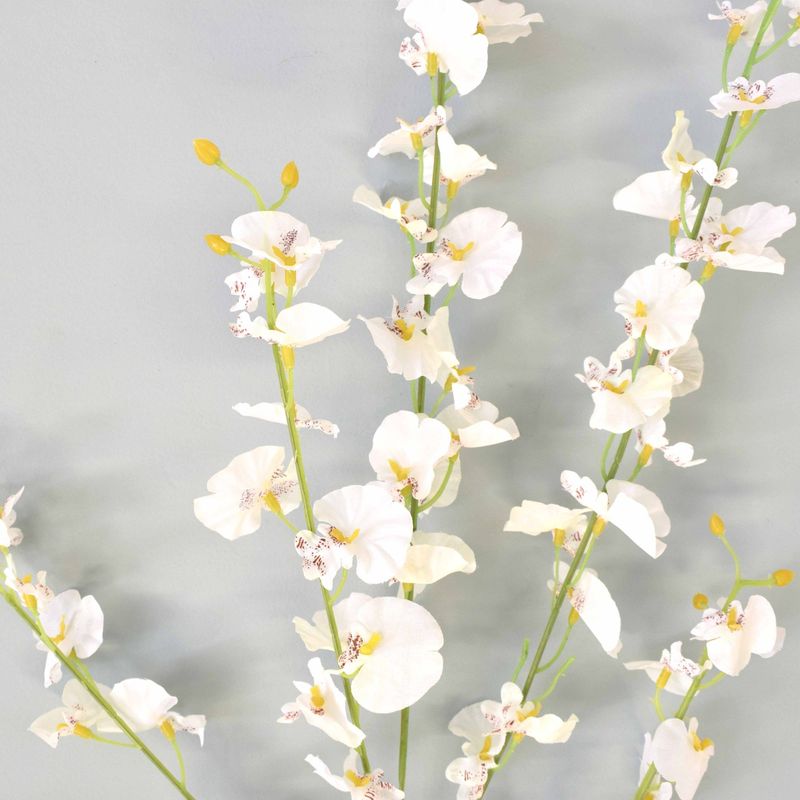 No centro, foco detalhado e aproximado das flores articiais de orquidea chuva de prata branca em fundo azul