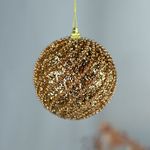 No centro, bola de natal texturizada dourada em fundo branco