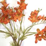 Foco aproximado mostrando detalhes das pétalas das flores artificiais laranja  em fundo branco