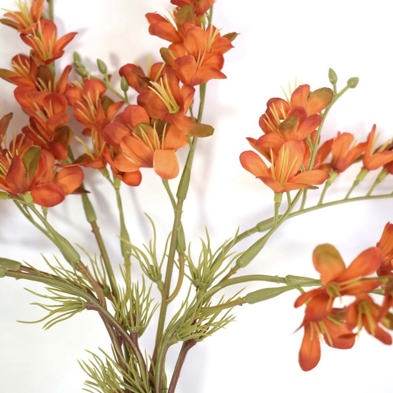 Foco aproximado mostrando detalhes das pétalas das flores artificiais laranja  em fundo branco