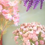 Composição de buquê de flor do campo cor-de-rosa do lado esquerdo, buquê de lavanda roxa canto superior direito e buquê de mosquitinho cor-de-rosa no canto inferior direito. Todos em fundo azul.