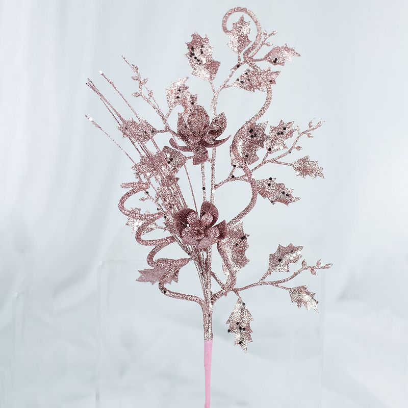 No centro, enfeite de natal pick de galhos, flores e folhas coberto de glitter rose gold em fundo branco