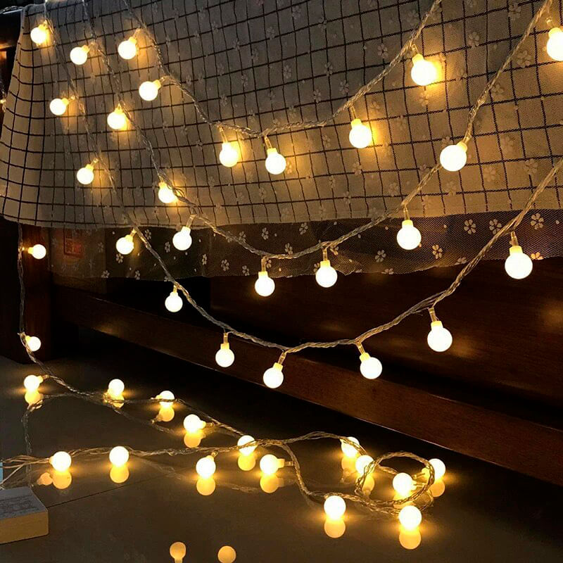 Fio elétrico com 40 mini lampadas brancas acessas com iluminação amarelada.